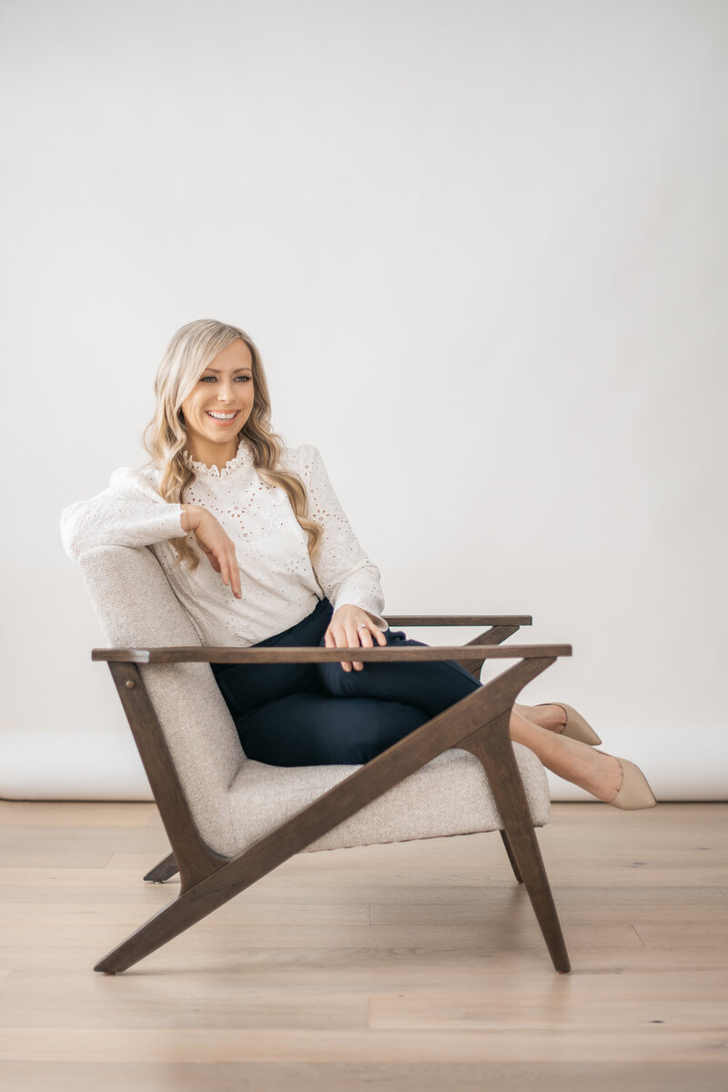 Dr. Tracy sitting in chair smiling