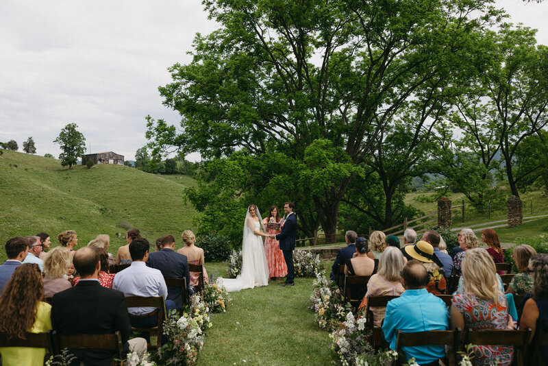 Bride and Groom gazing out at their guests during their summer wedding in the mountains of Asheville NC and the Blue Ridge, documented by Andrea-Marie Photography