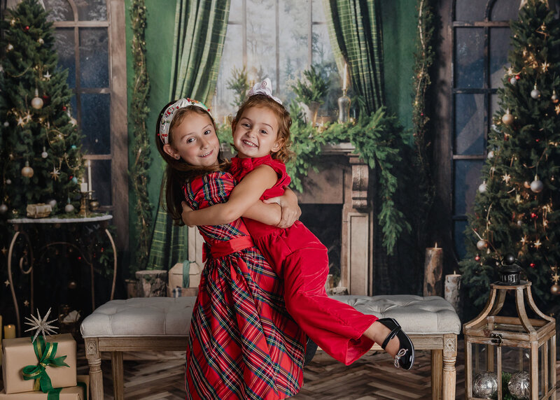 Holiday portrait of hugging siblings at Allison Reilly's Union County, NJ photo studio.