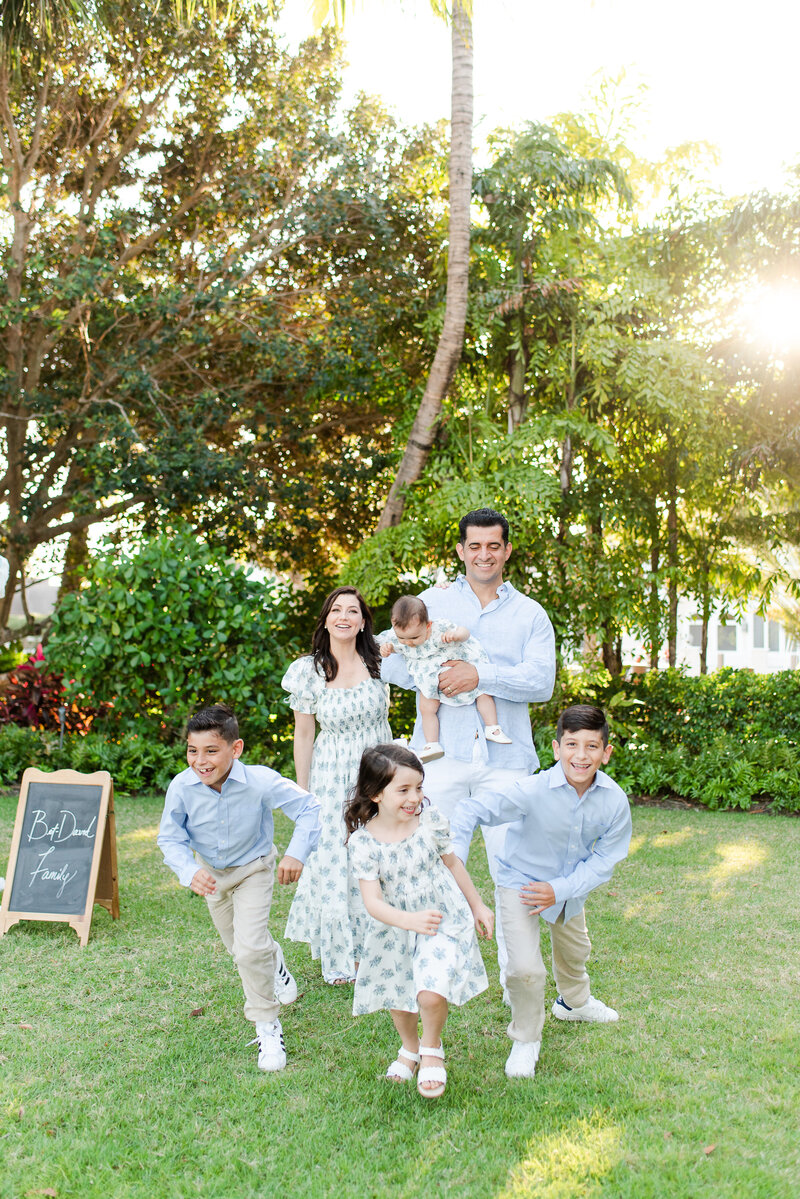 Mom and dad with 4 kids matching outfits at the park for a photoshoot by Miami Lifestyle Photographers David and Meivys of MSP Photography
