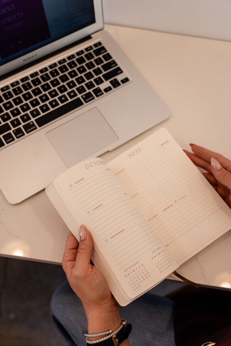 Open planner and laptop used for planning Shopify ecommerce, Faire wholesale, copywriting, and website design projects for small business clients.