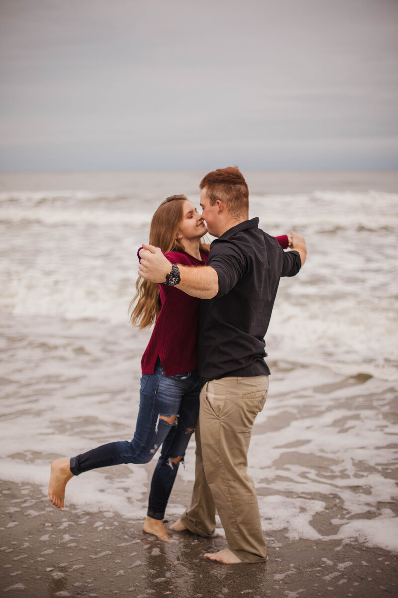 man and woman on beach during outdoor engagement session