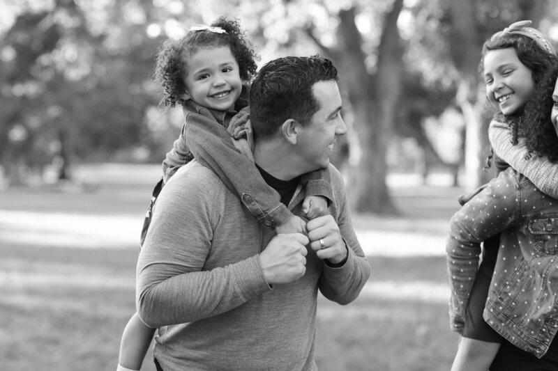 A black and white photo of a family in a park captured by an Austin wedding photographer.