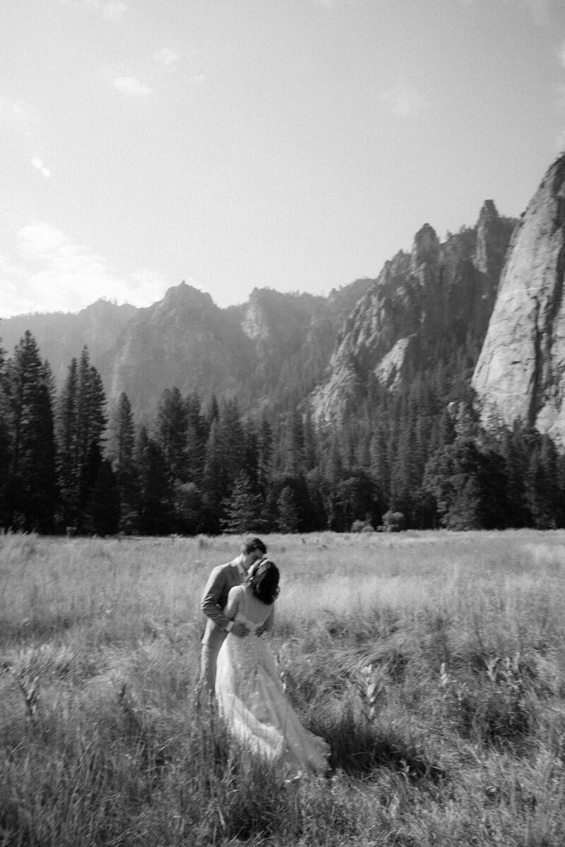 Couple shares a romantic kiss in black and white at El Capitan in Yosemite on their elopement day. 