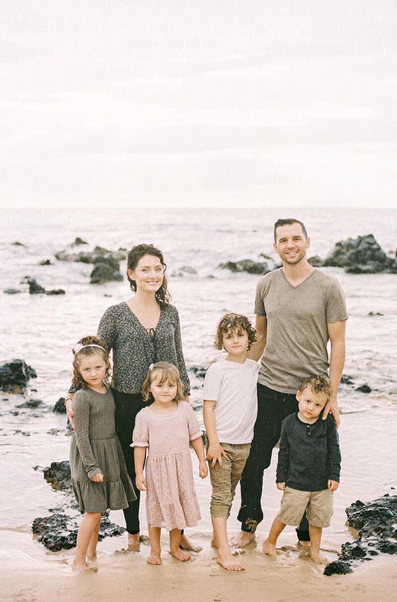 Family on beach during rain in Maui