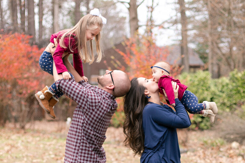 mom and dad hold daughters in the air in kennesaw