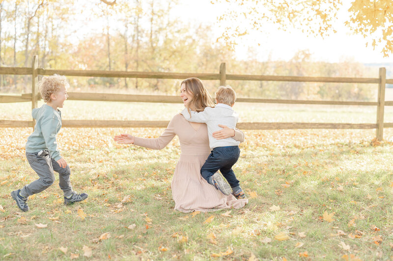 boy running towards mom and brother during Oakton, Virginia fall mini session