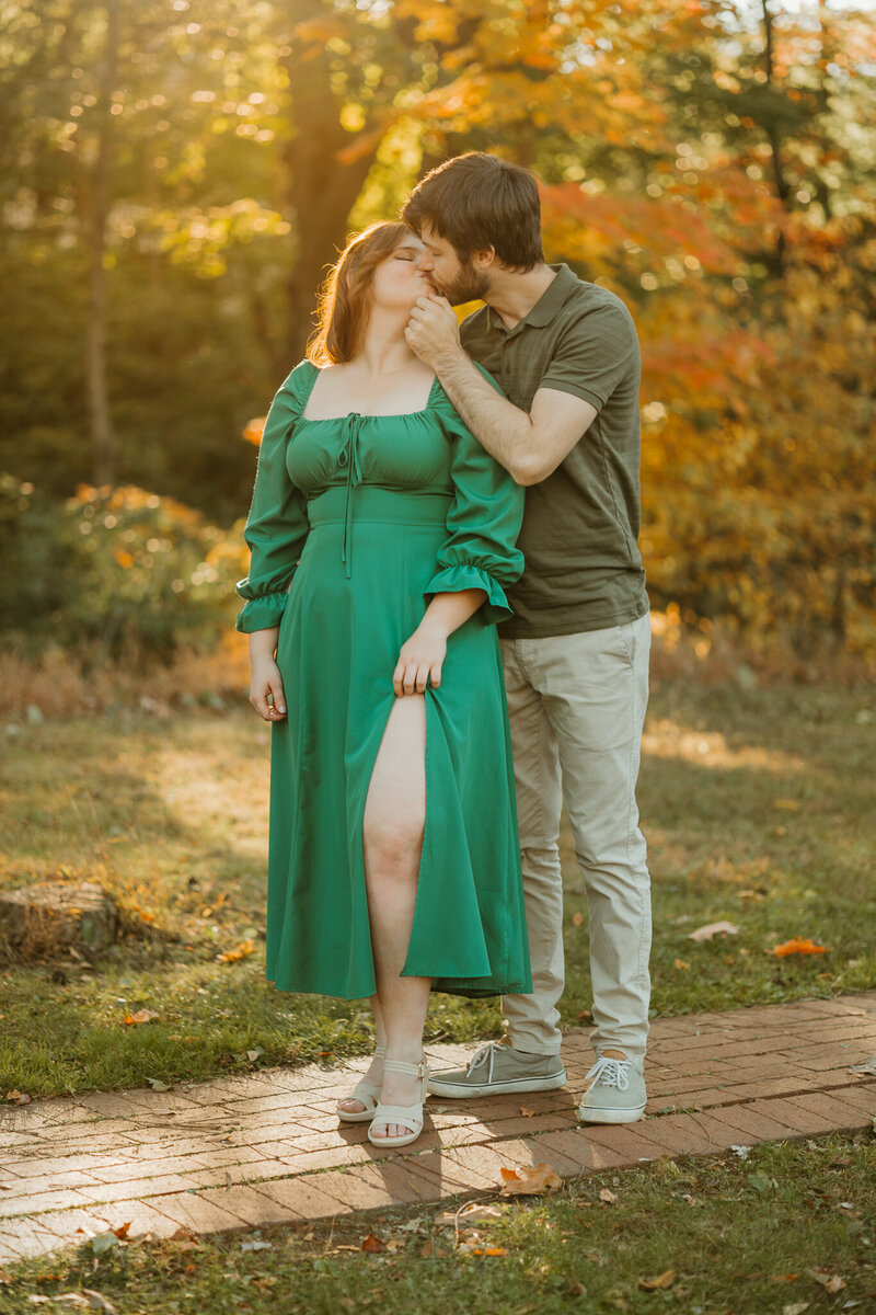 Couple share an intimate kiss wrapped in the fall sunlight at Lockridge Park in Alburtis 