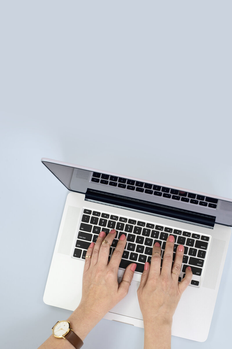 Social media manager typing on a laptop, creating content for clients.
