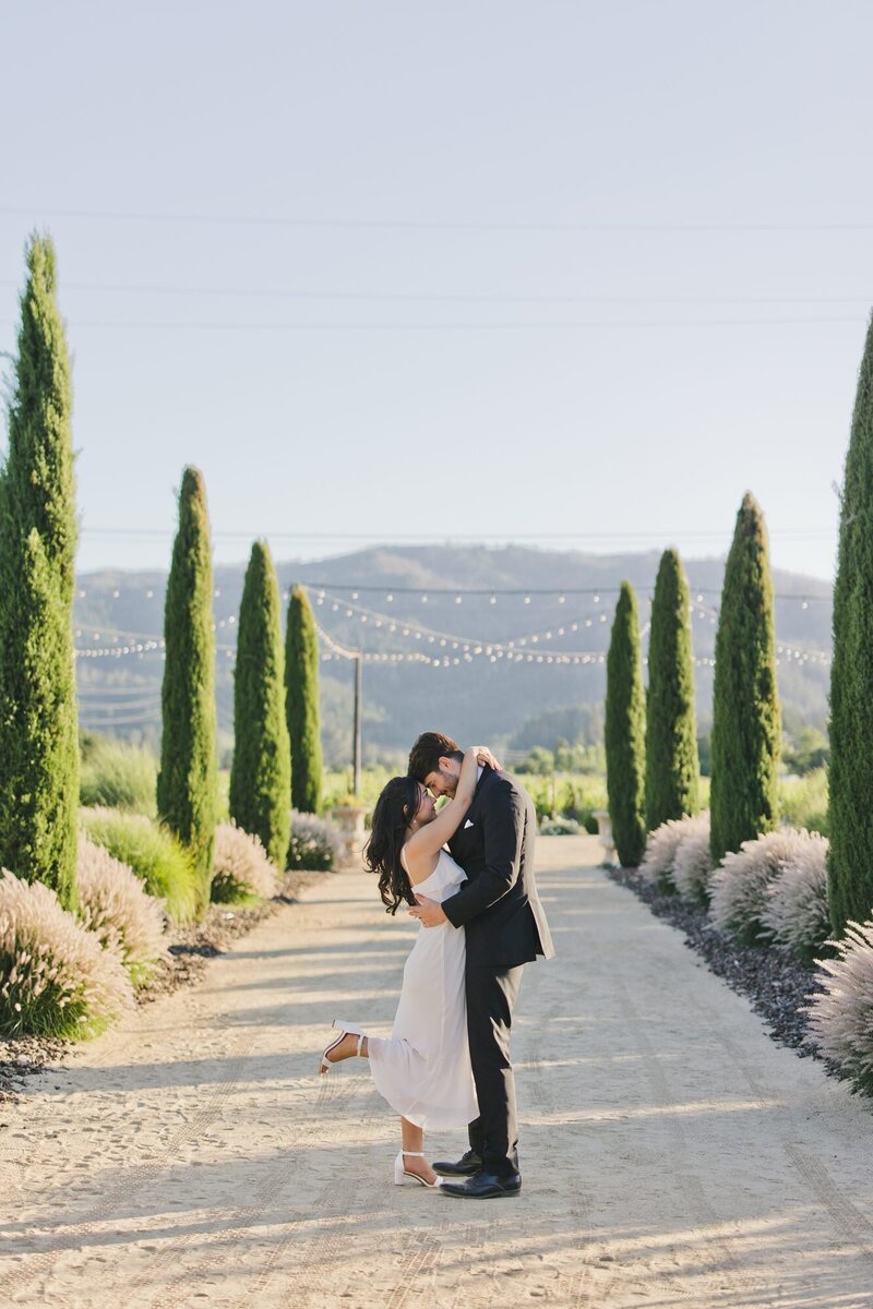 A bridge and groom holding each other in a loving embrace taken as a candid and natural wedding photo by One Love Photography.