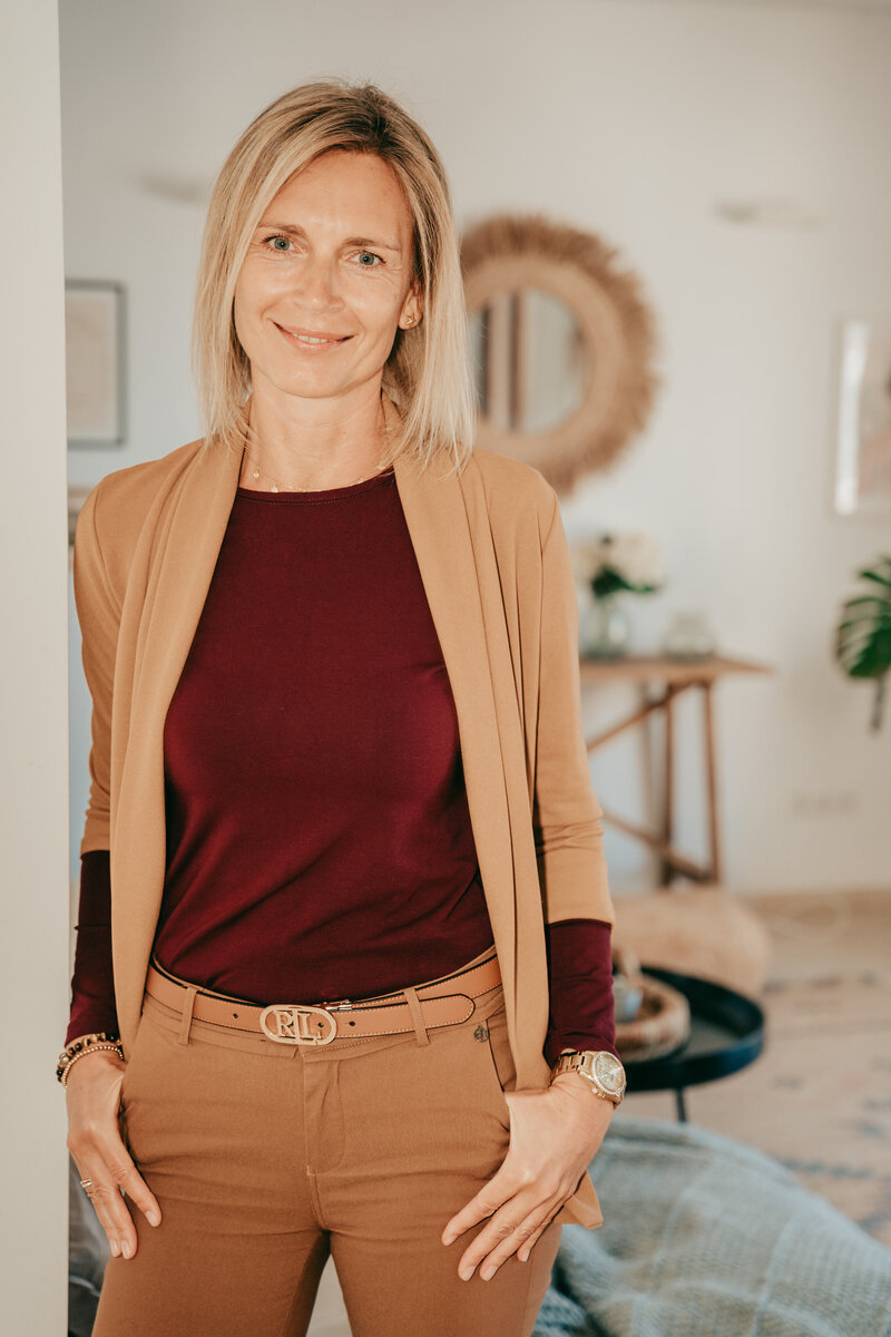 Sylke lächelnd an einer Säule stehend
