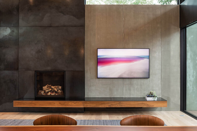 Concrete wall cladding in modern home living room next to fireplace with floating mantel