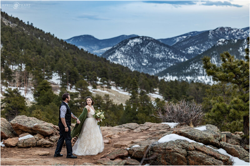 Couple walk on the rocky outcrop at 3M Curve on their wedding day at Rocky Mountain National Park
