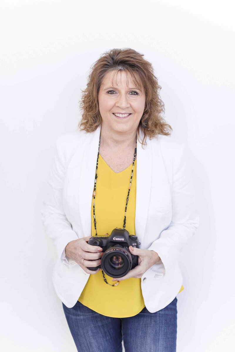 woman in yellow shirt leaning against wall