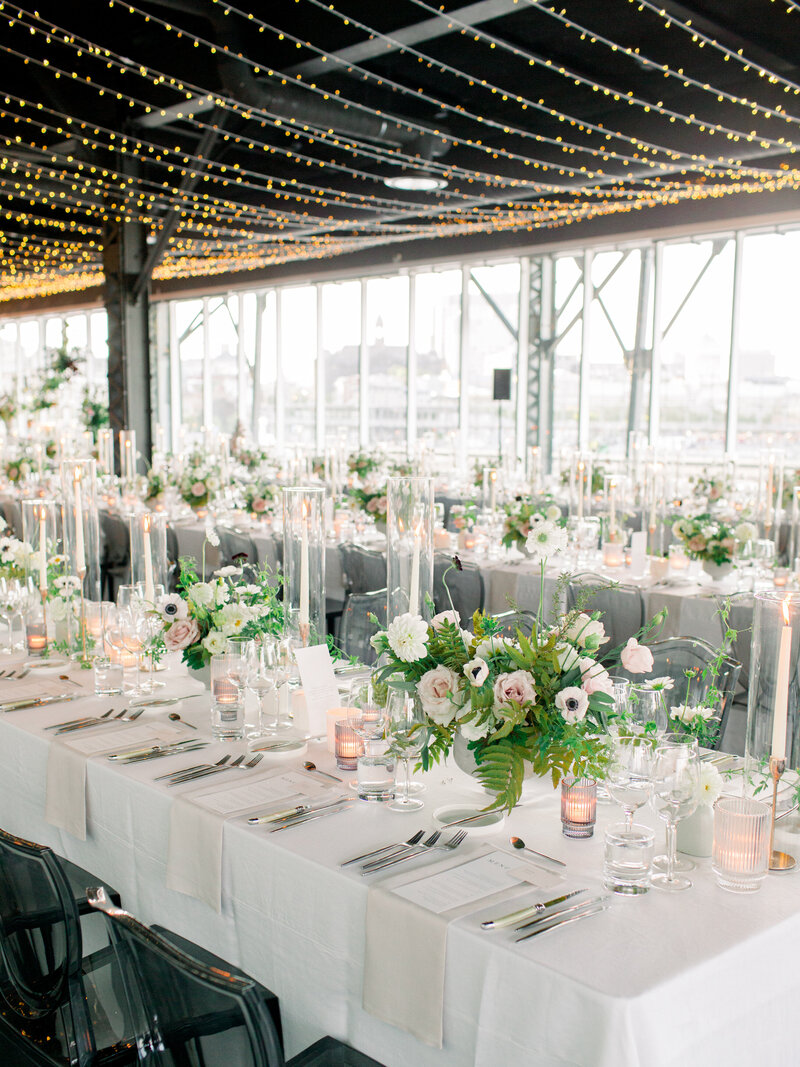 Elegant table settings with white and green flowers at a Science Centre wedding reception.