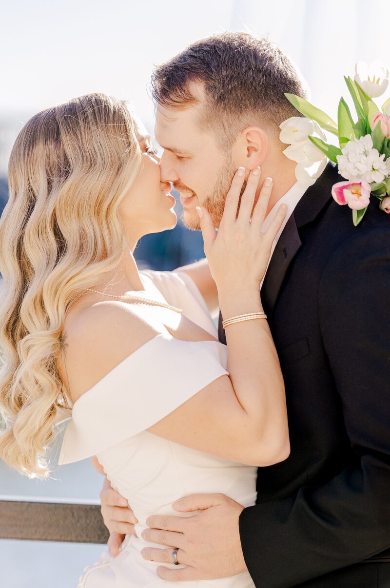 An elegant bride leans in for a kiss from her groom.