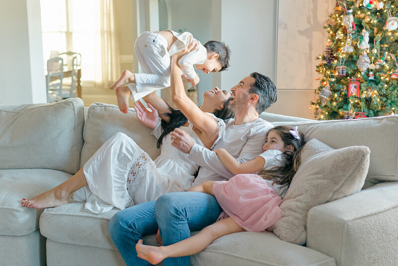 Mom and dad playing with kids on couch