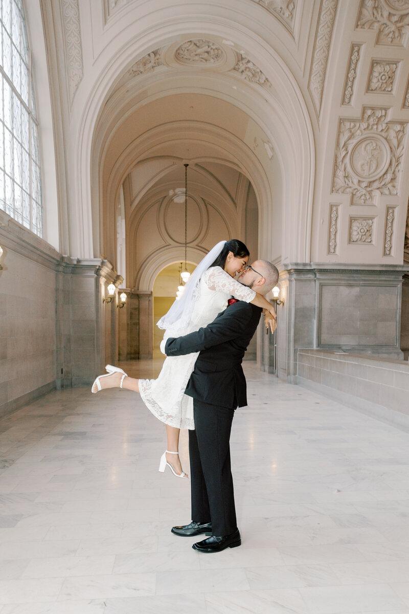 San Francisco City hall elopement couple embrace during portraits with a bay area wedding photographer in San Francisco, CA