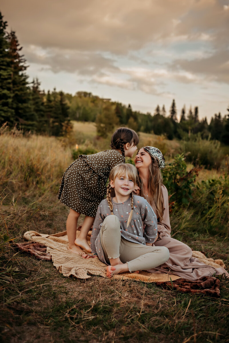 mom and dad hold baby during fall family photo shoot with Edmonton's best family photographer