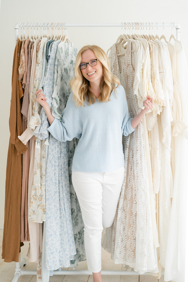 Julie Brock, newborn and family photographer, shows clients clothes they can wear at her Louisville KY studio.