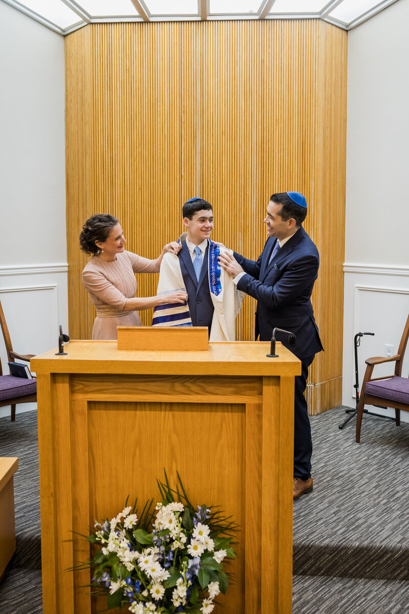Parents proudly look at son during Bar Mitzvah.