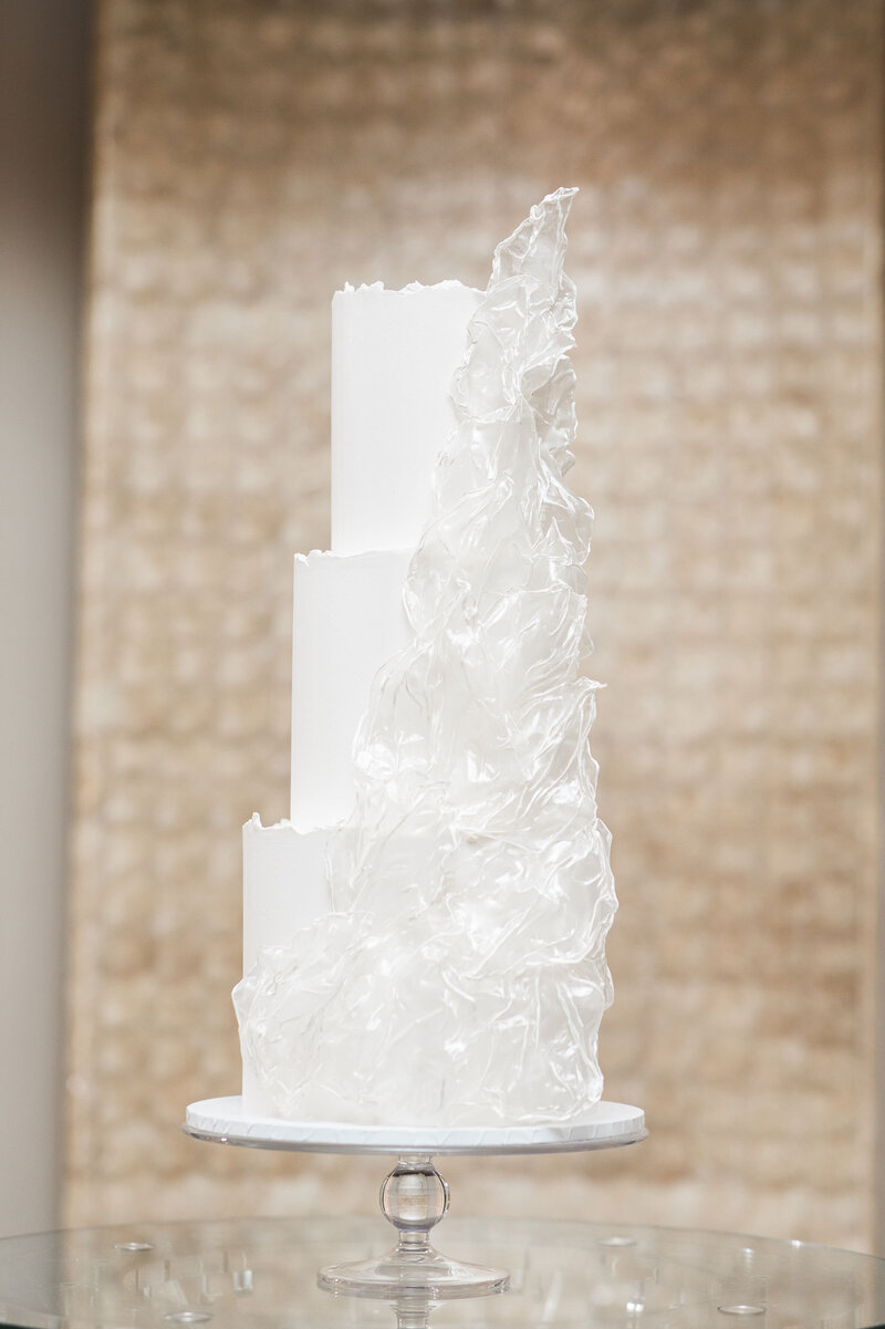 Three tier modern wedding cake - all white with white wafer paper sails set up at The Dorchester Park Lane London