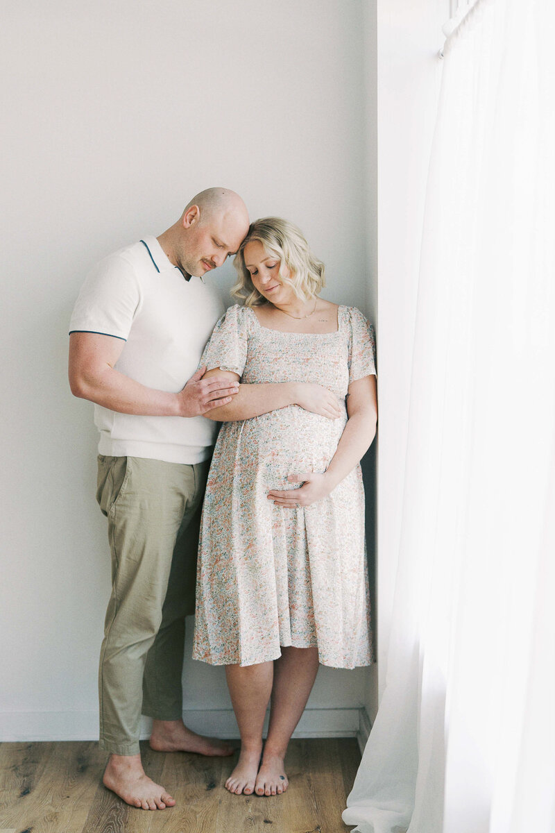 an expecting mom holding her toddler daughter