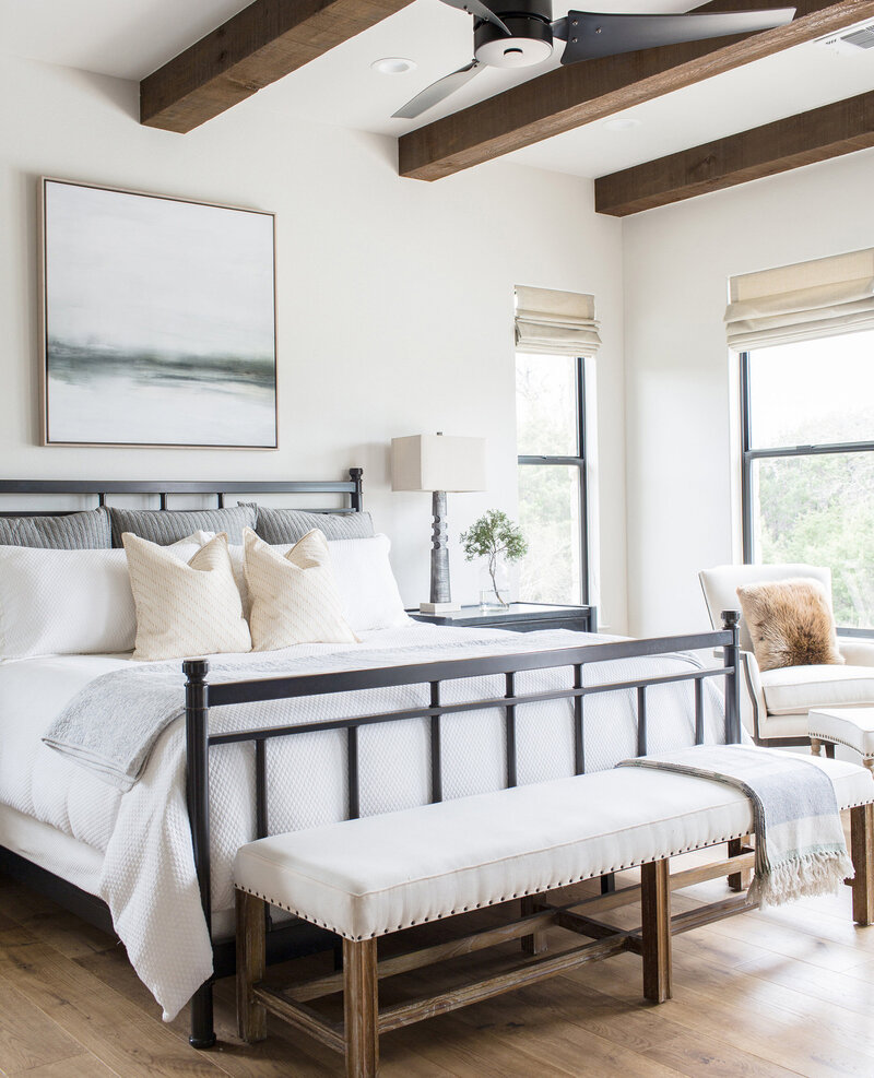 Airy and neutral bedroom with exposed wood beams