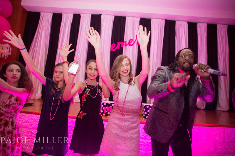 Teens and DJ dancing under pink lights