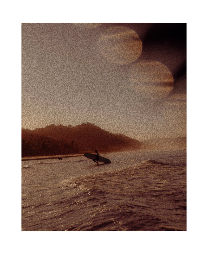 film photo of a surfer walking on the beach