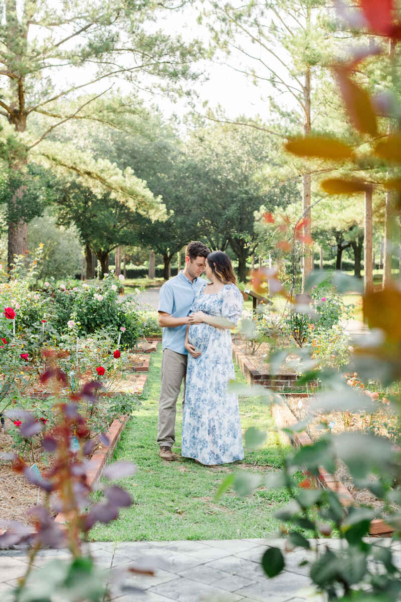 Man and Woman standing closely posing in a dothan alabama garden for maternity photography session
