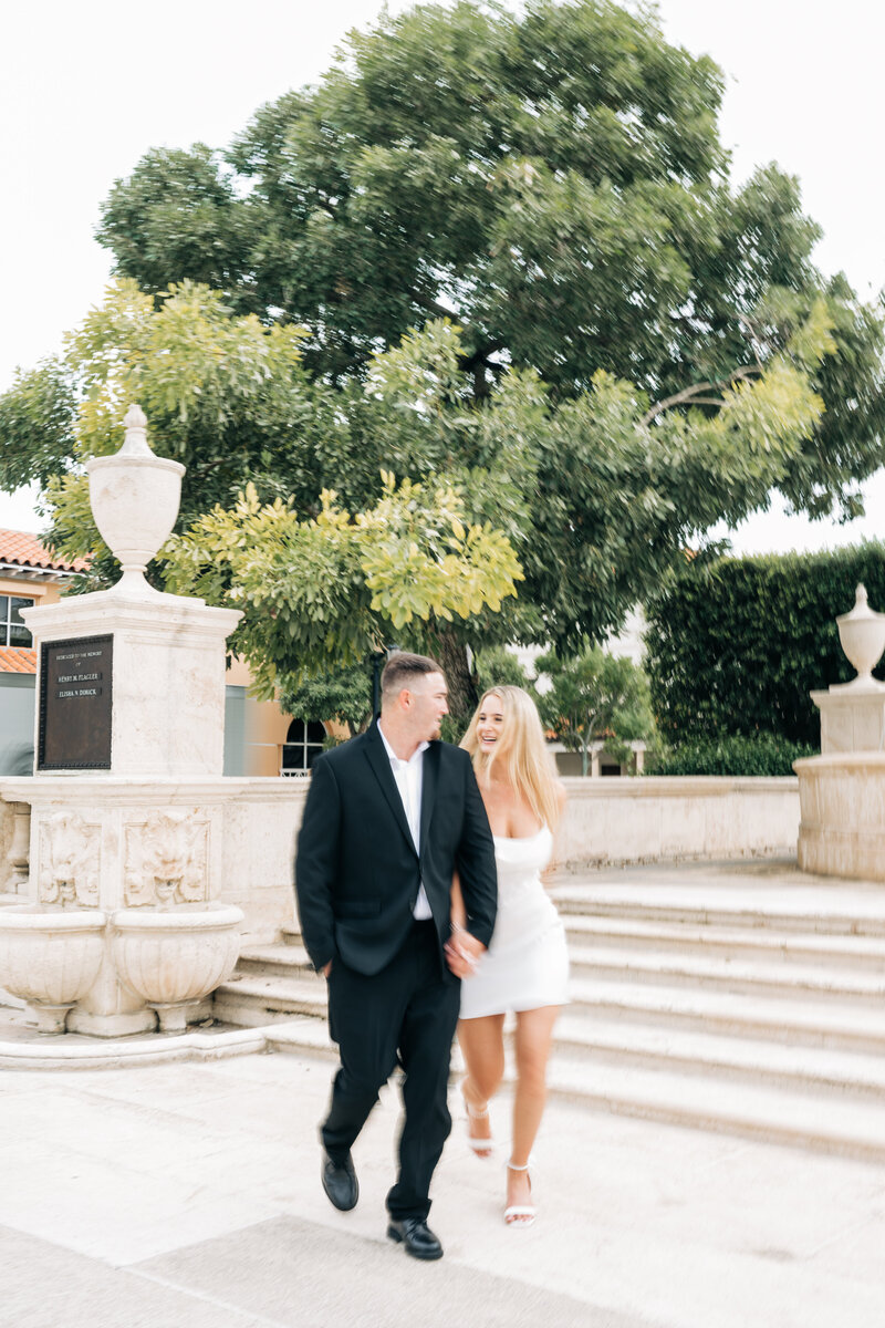 Couple having fun at their engagement session by Palm beach engagement photographer