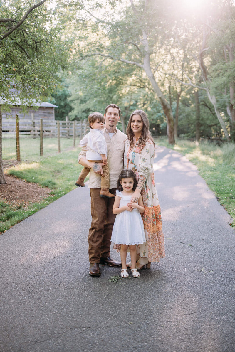 Mom, Dad, Boy and Girl pose together in park for family portraits.