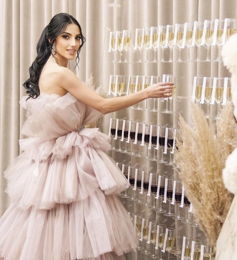 woman taking champagne glass off a champagne wall