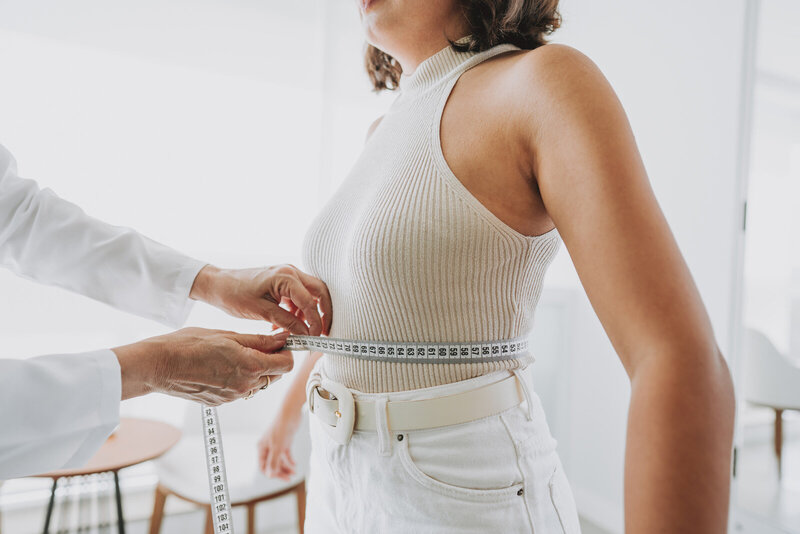 Woman having her waist measured