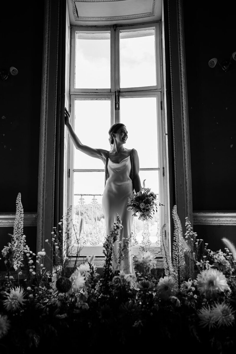 bride in southwark park after dilston grove wedding, long white skirt and lace top, flowers in hair