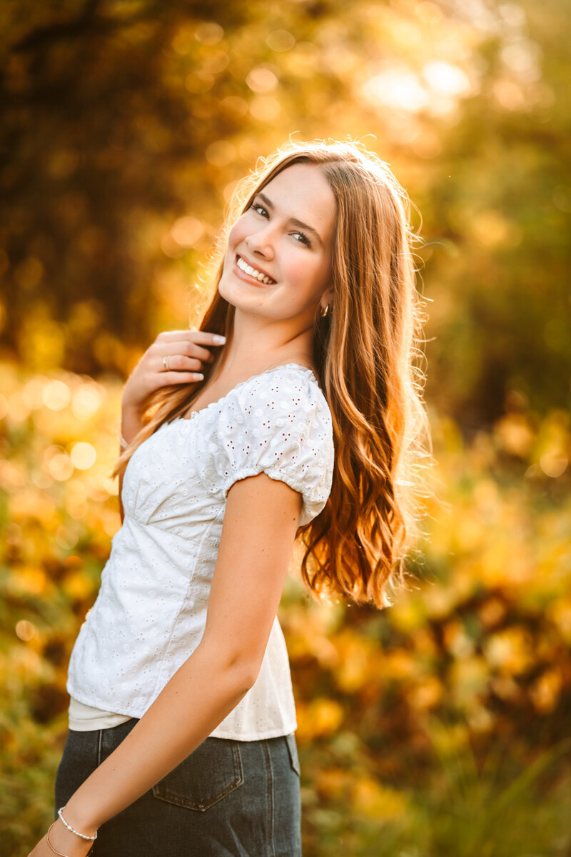 Senior girl graduate holding her cap and gown by annie bee photography.