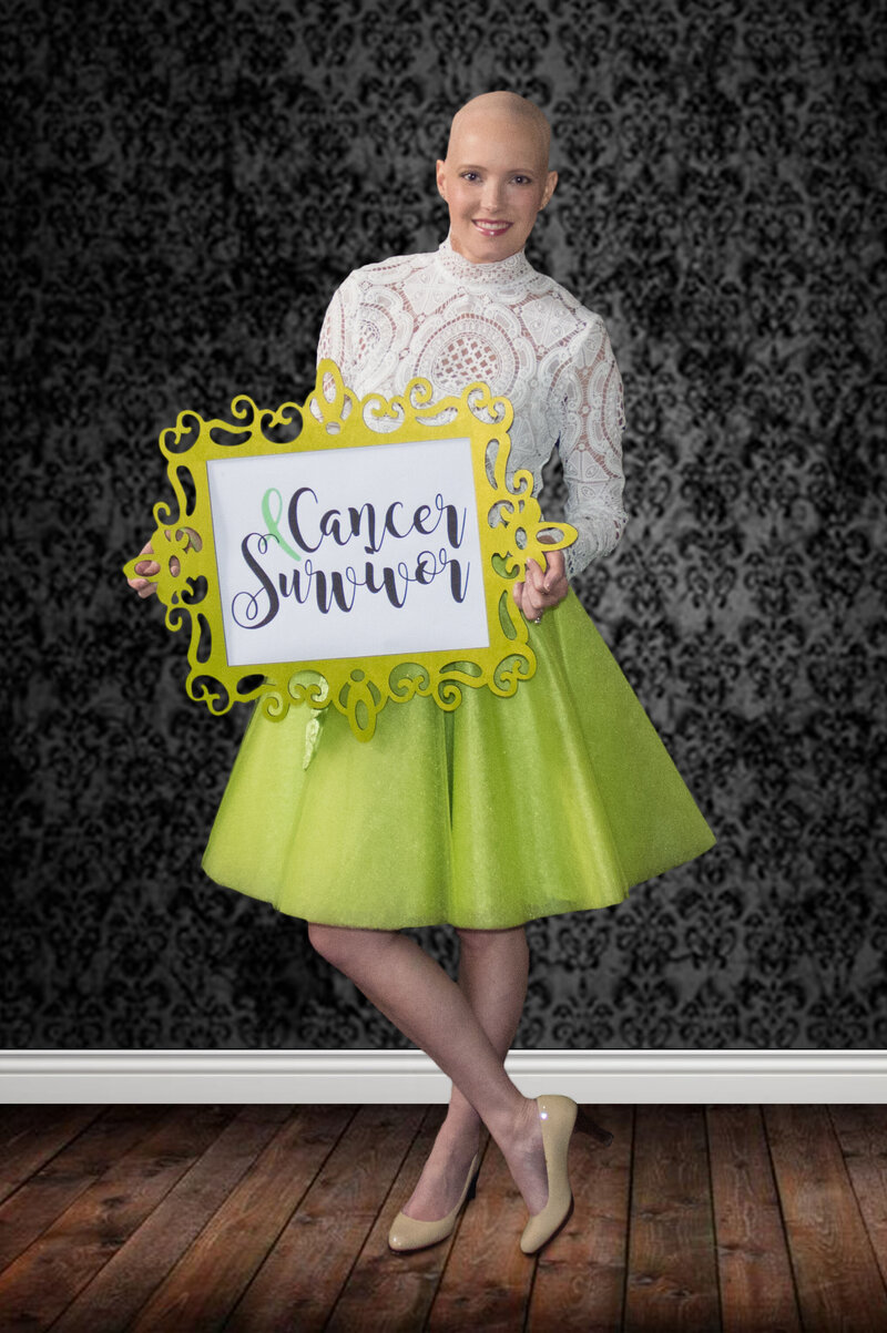 bald woman holding a sign that says "Cancer Survivor"