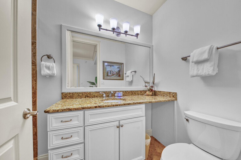 bathroom with granite countertop and white cabinets
