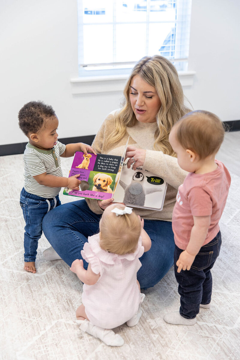 Woman reading a book to toddlers