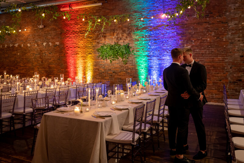 Gay couple embracing at their wedding dinner reception in Milwaukee Wisconsin Q Jancola