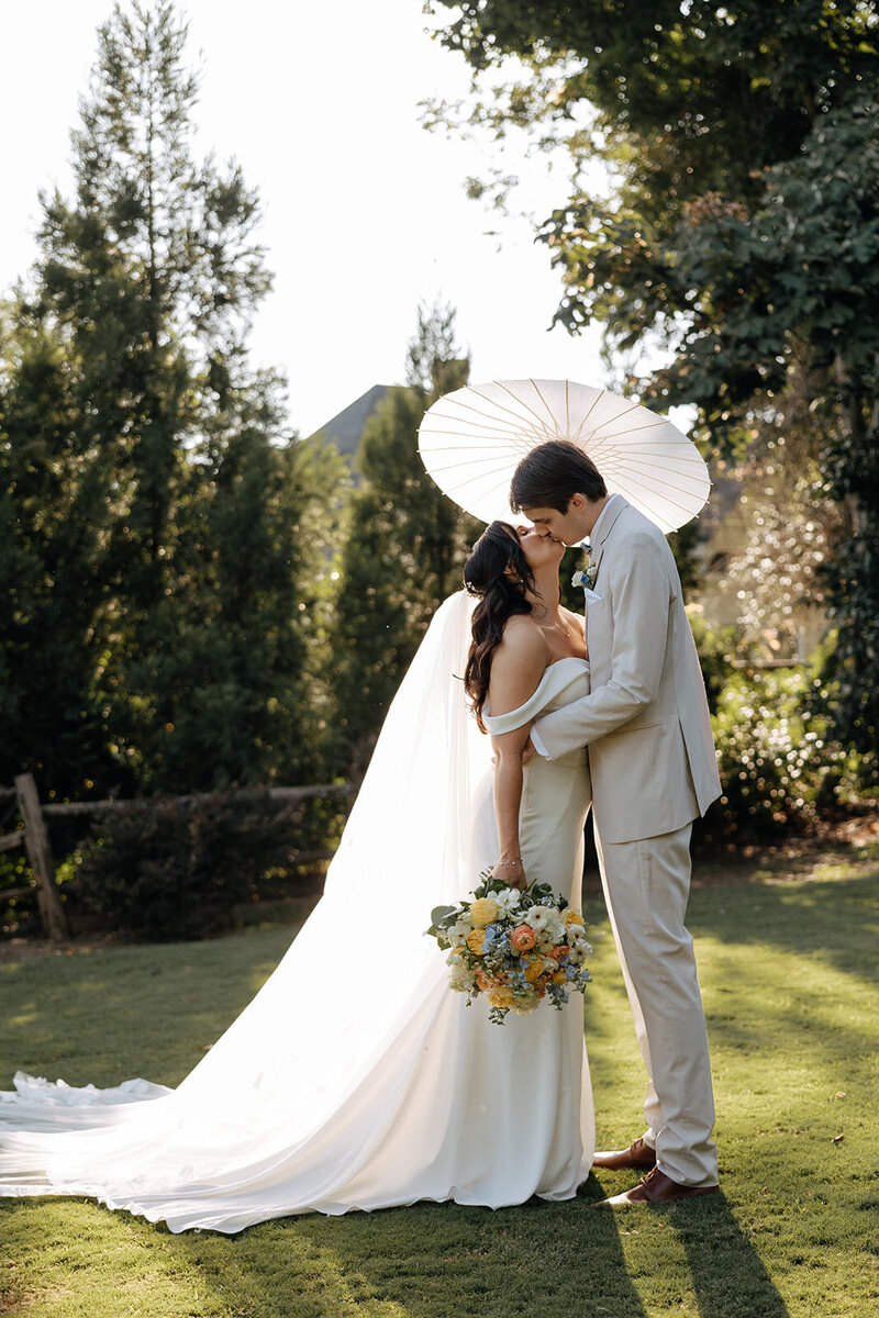 Couple pose with white sunbrella during their Atlanta wedding documented by Rachel Boyd Photography