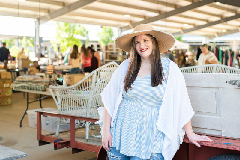Lauren smiles at an antique market in wide brimmed hat