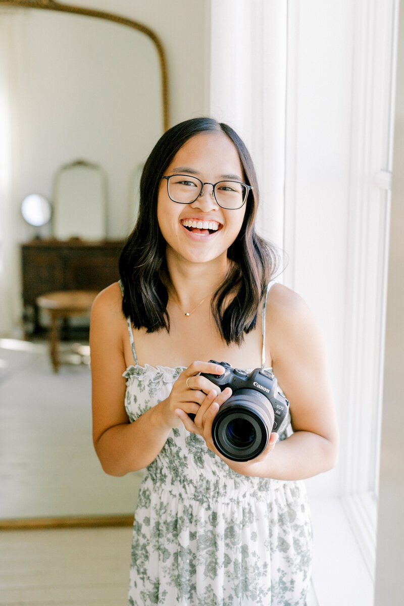 girl holding camera laughing