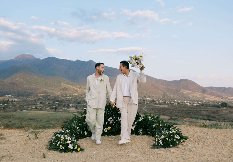 LGBT Wedding: Real Love in the Mountains – Happy Couple Holding Hands, Gazing at Each Other.