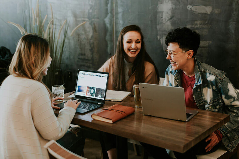 Group of real estate agents sitting at a table and laughing