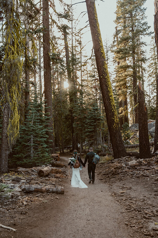 bride and groom hiking along the trail to taft point in yosemite