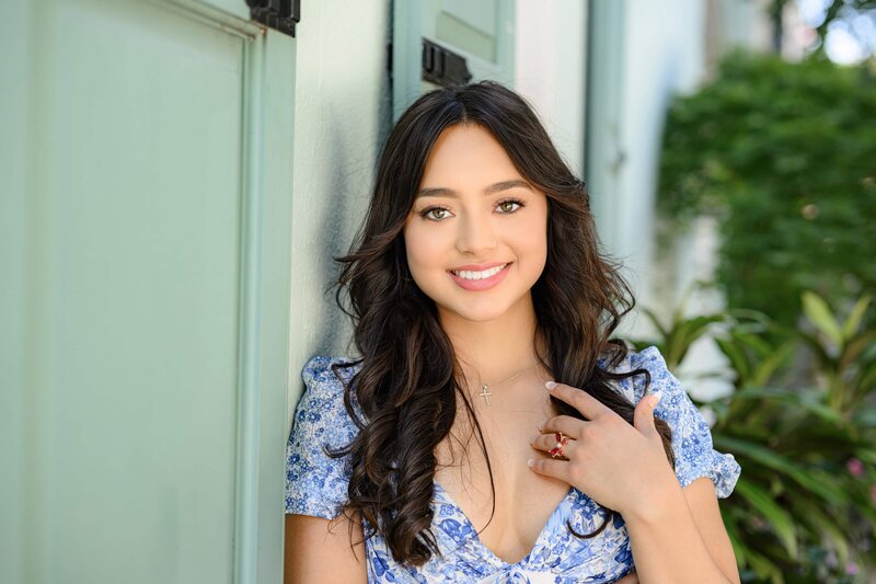 Dark hair waxhaw senior poses against a wall on rainbow row in charleston, sc