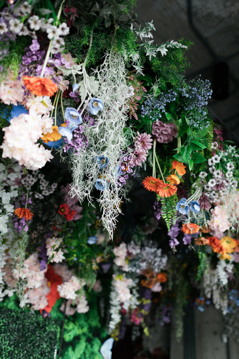 lush faux floral hanging installation at a wedding reception