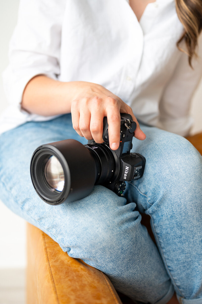 A close up shot of Kala holding her camera. You cannot see her face.